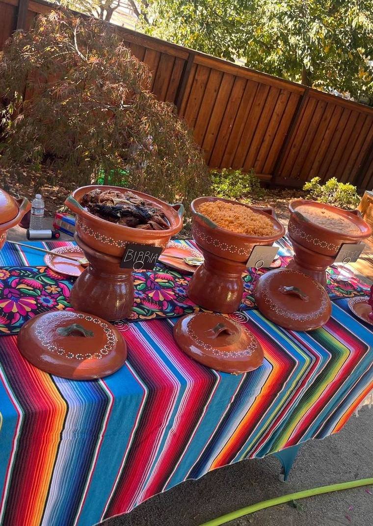 Taco Man catering table with birria, rice and beans in clay pots